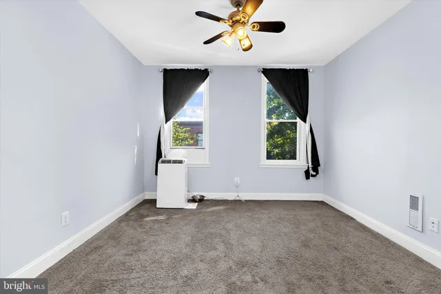 an empty room with a window and a ceiling fan