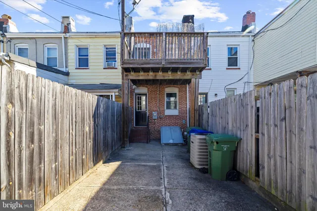 a view of a house with wooden fence next to a porch