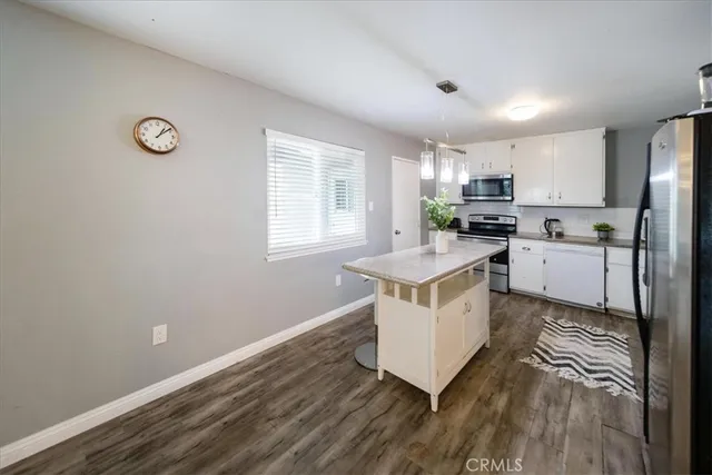 a kitchen with a refrigerator a stove a microwave and white cabinets