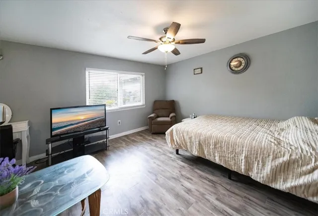 a spacious bedroom with a bed and wooden floor