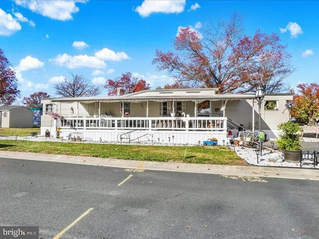 a porch with a table and chairs under an umbrella
