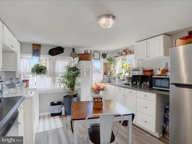 a kitchen with stainless steel appliances a sink a table and chairs