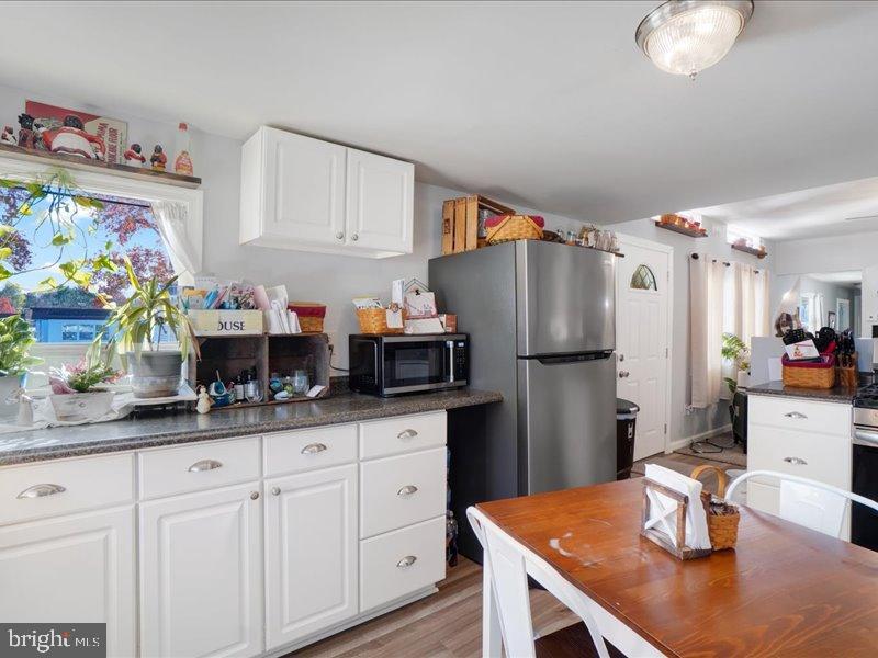 143 Pawnee Avenue Dover, PA 17315 - Photo 7 of 23 a kitchen with stainless steel appliances granite countertop a refrigerator a sink dishwasher and white cabinets with wooden floor