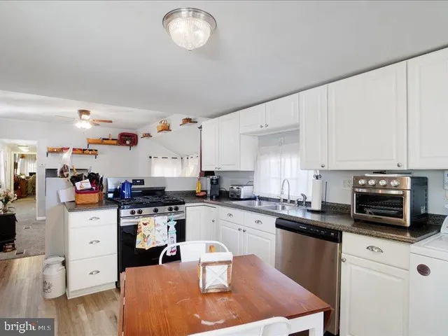 a kitchen with granite countertop a sink appliances and cabinets