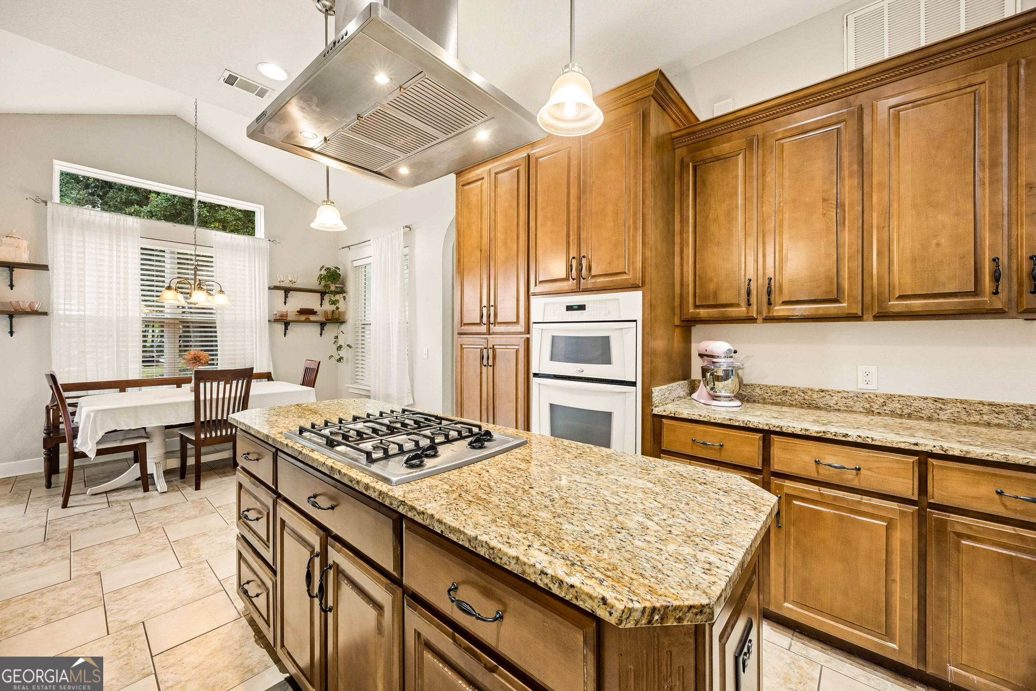 706 Hopewell Point Road White Oak, GA 31568 - Photo 23 of 84 The expansive granite-topped island serves as the centerpiece of the kitchen, featuring a gas cooktop, abundant storage, and ample workspace for gathering and meal preparation.