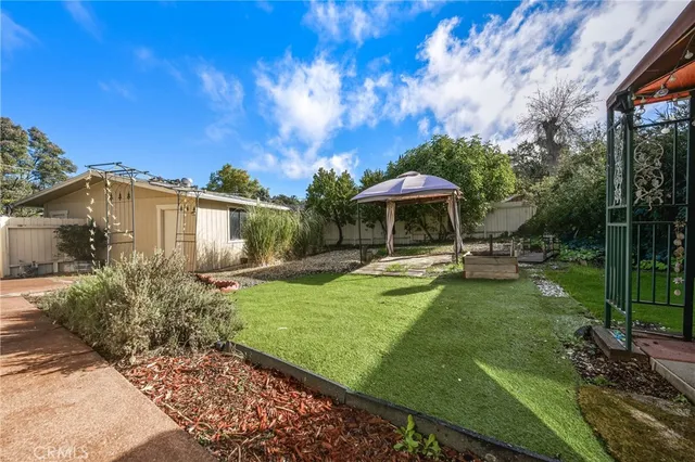 a view of a house with backyard sitting area and garden