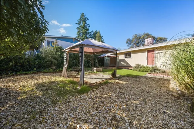 a backyard of a house with barbeque oven table and chairs