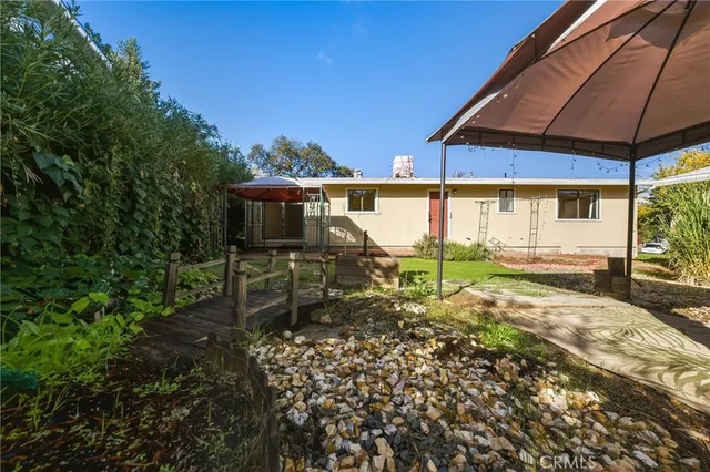 a view of a house with backyard and sitting area