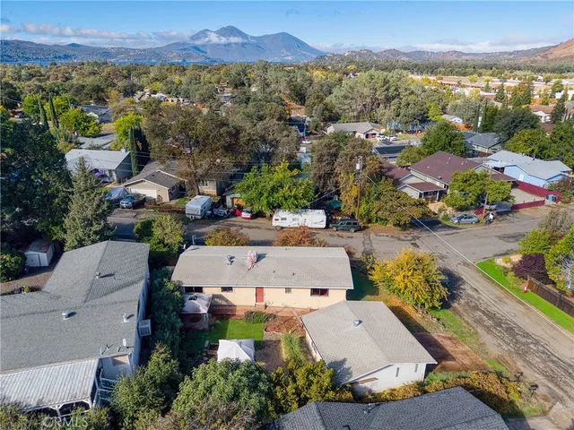 an aerial view of residential houses with outdoor space and trees