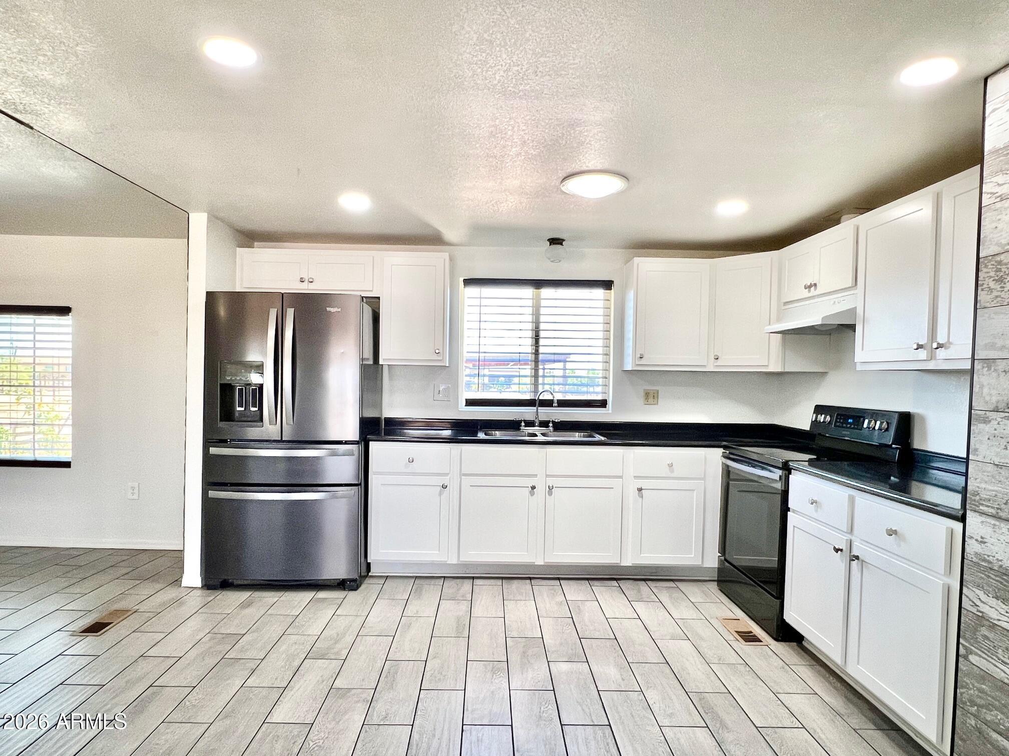 12035 East Tennyson Road Florence, AZ 85132 - Photo 4 of 42 a kitchen with stainless steel appliances granite countertop a refrigerator and a stove top oven