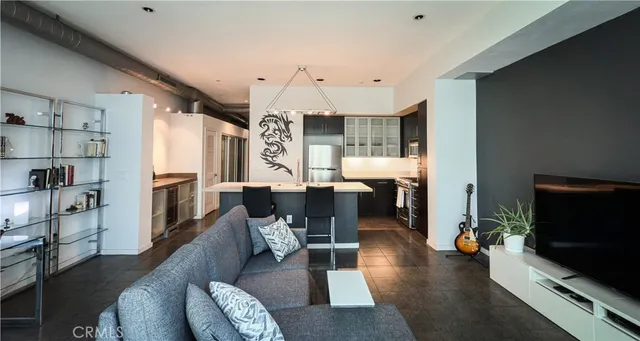 a living room with furniture flat screen tv and chairs