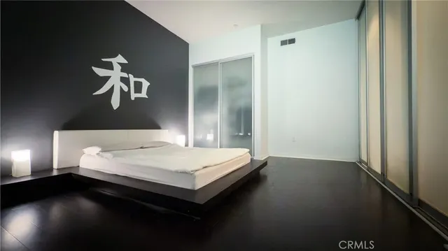 a bedroom with a large bed and a chandelier