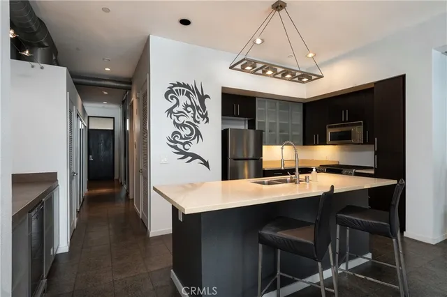a kitchen with a table chairs refrigerator and a sink