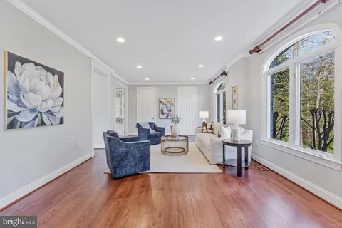 a kitchen with stainless steel appliances kitchen island granite countertop a refrigerator a stove a sink a dining table and chairs with wooden floor