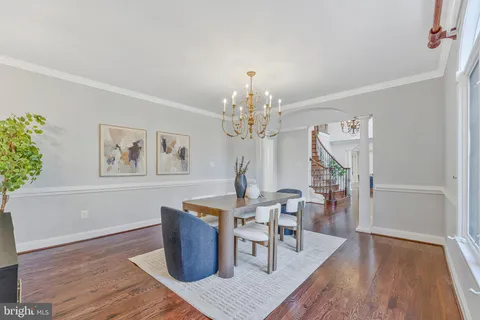 a dining room with furniture a chandelier and wooden floor