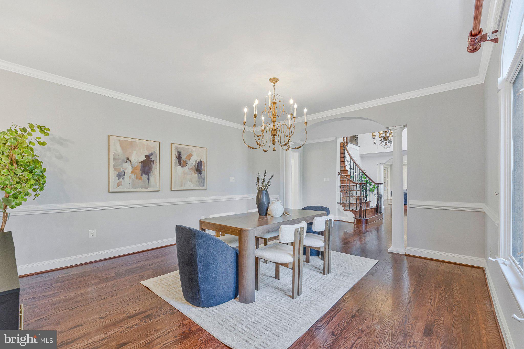 8611 Brook Road McLean, VA 22102 - Photo 18 of 104 a dining room with wooden floor a chandelier a wooden table and chairs