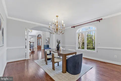 a view of a dining room with furniture a chandelier and wooden floor