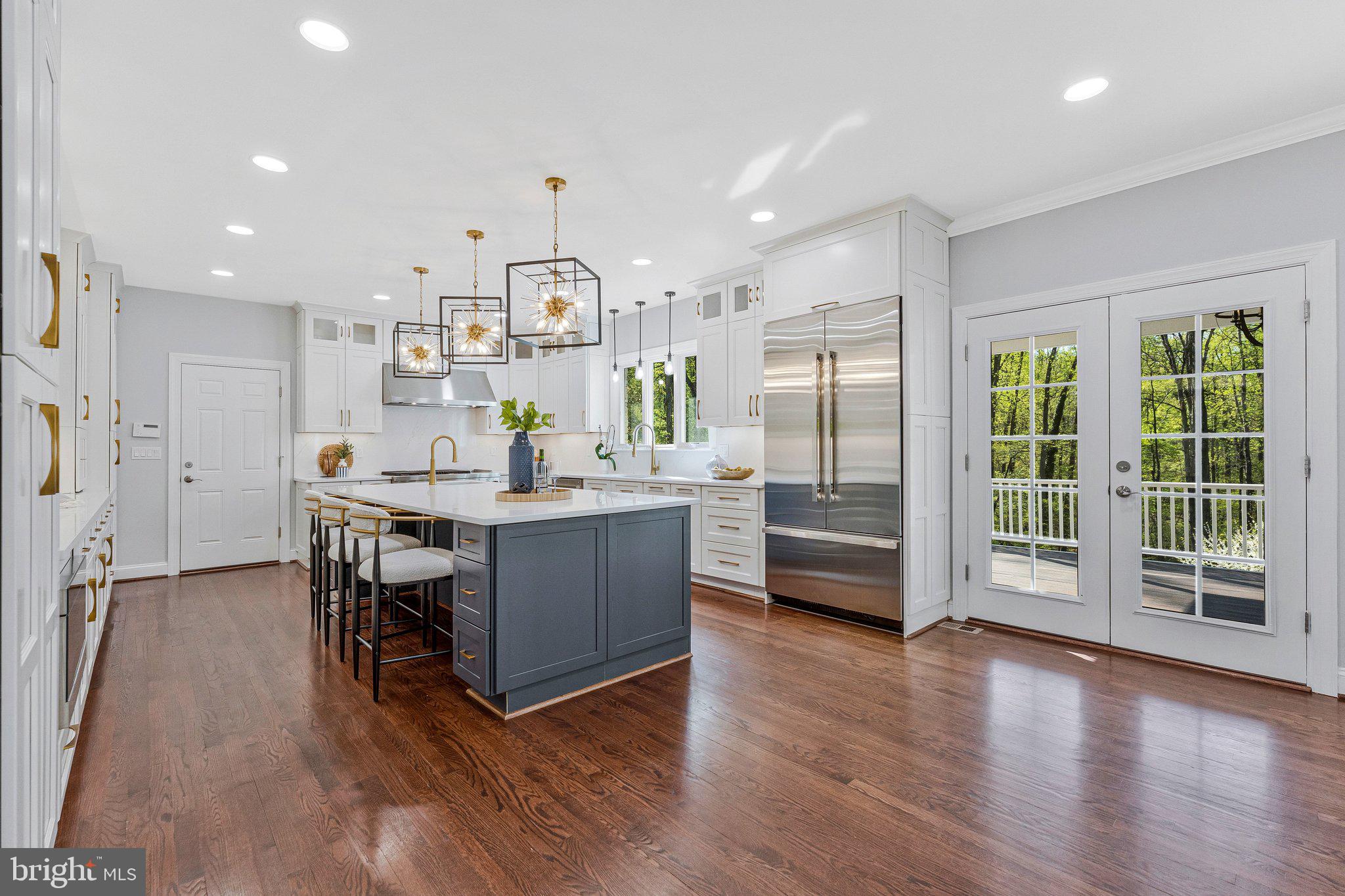 8611 Brook Road McLean, VA 22102 - Photo 22 of 104 a kitchen with stainless steel appliances kitchen island granite countertop a refrigerator a stove a sink a dining table and chairs with wooden floor