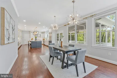 a view of an entryway wooden floor and dining room
