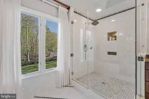 a bathroom with a granite countertop sink toilet a mirror a bathtub and shower
