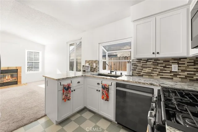 a kitchen with granite countertop a stove sink and cabinets