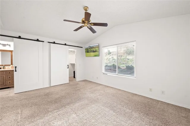 a view of a room with a ceiling fan and refrigerator