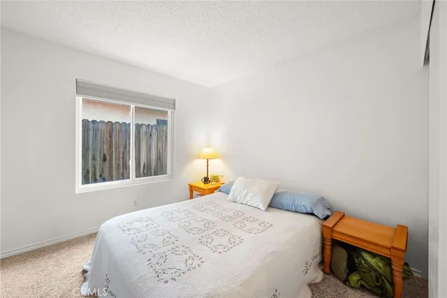 a bedroom with a bed and a lamp with the view of bathroom
