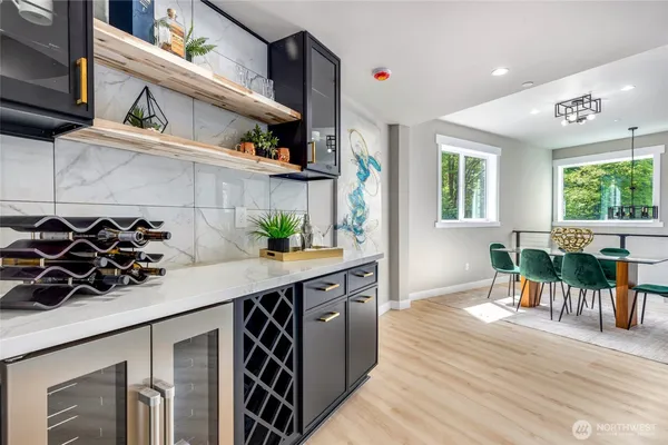 a kitchen with stainless steel appliances a sink dishwasher a refrigerator and a stove with wooden floor
