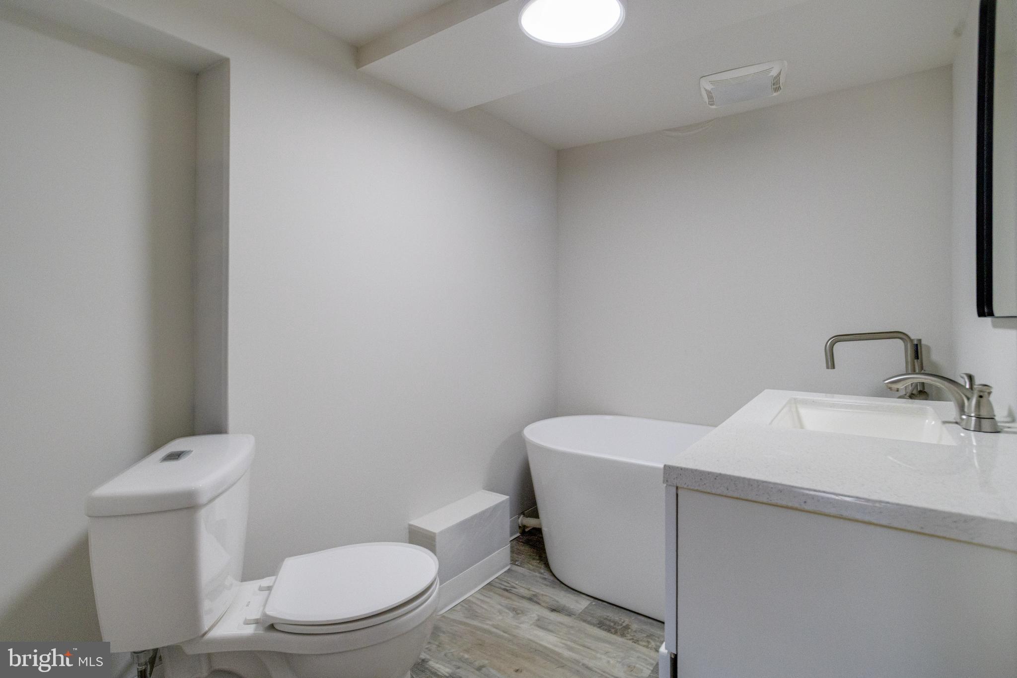 5878 Belair Road Baltimore, MD 21206 - Photo 20 of 41 a white toilet sitting next to a bathroom sink