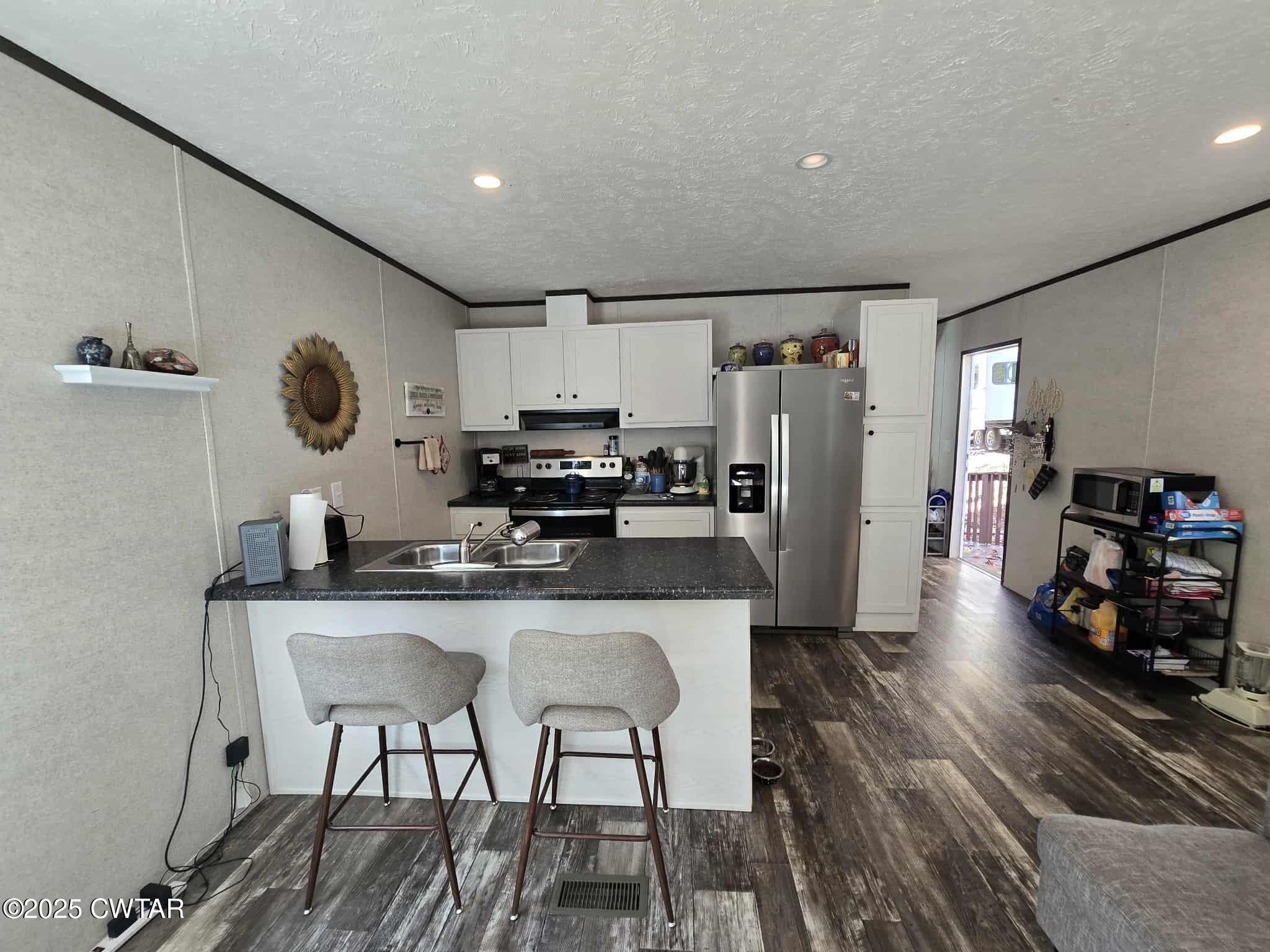 263 Porter Hollow Road Linden, TN 37096 - Photo 3 of 20 a kitchen with stainless steel appliances granite countertop a sink refrigerator and cabinets