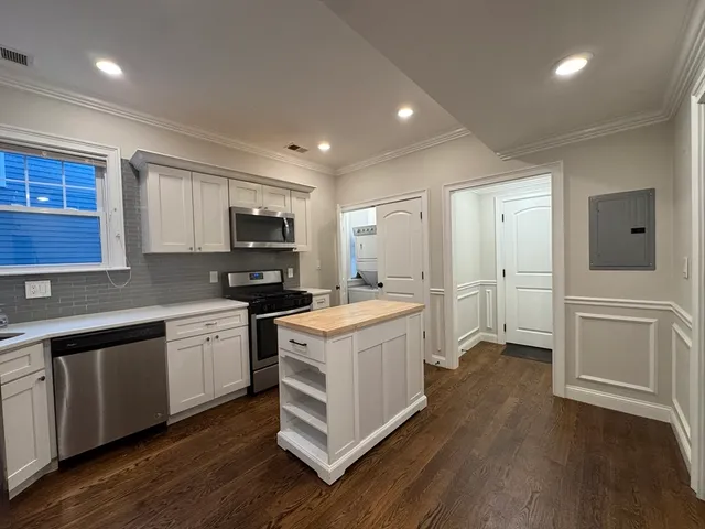 a kitchen with a stove top oven and refrigerator