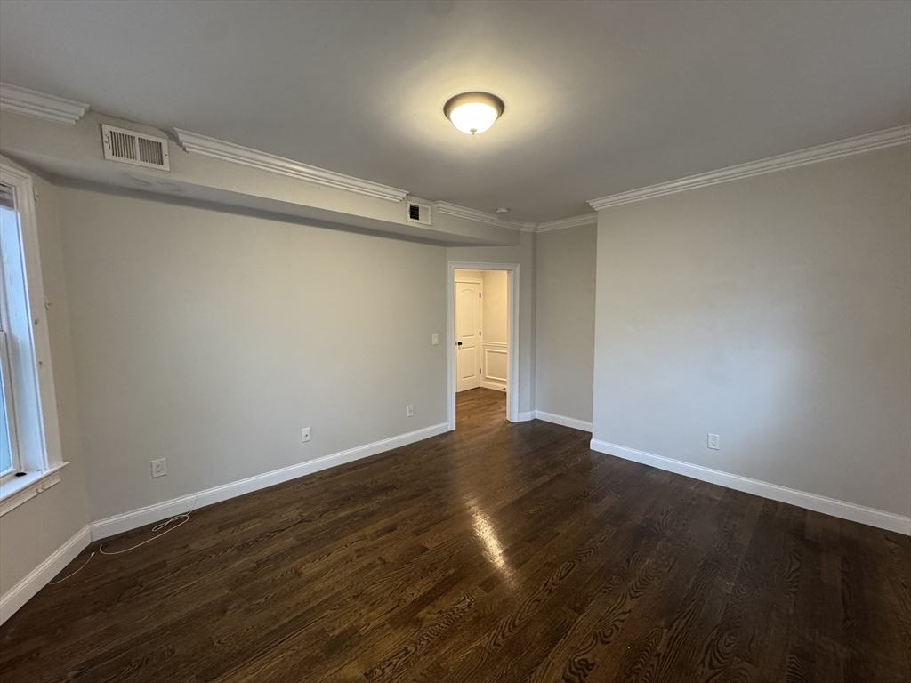 9 Cornwall Street, Unit 1 Boston, MA 02130 - Photo 6 of 22 a view of an empty room with wooden floor and a window