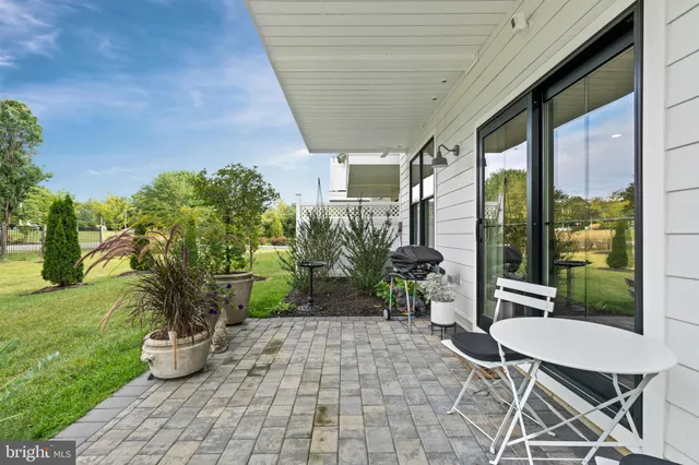 a view of a porch with chairs and potted plants