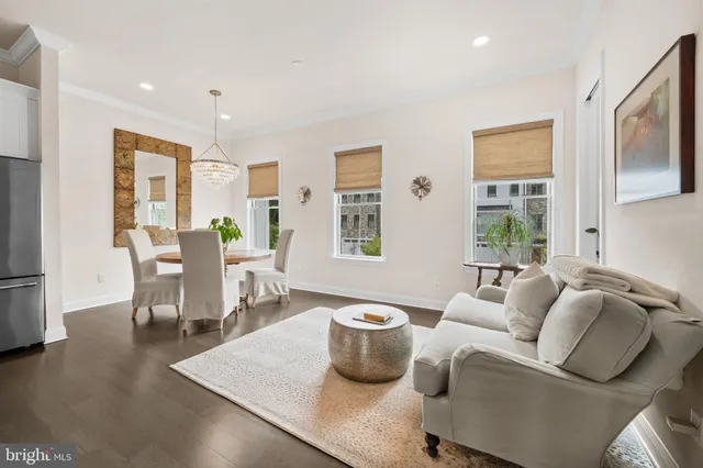 a dining room with furniture a chandelier and wooden floor