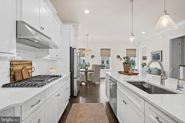 a kitchen with stainless steel appliances a sink a stove top oven a counter space and cabinets
