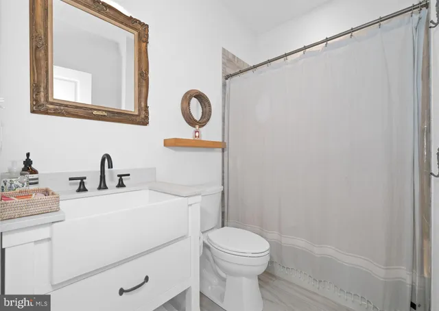 a bathroom with a toilet sink vanity and mirror
