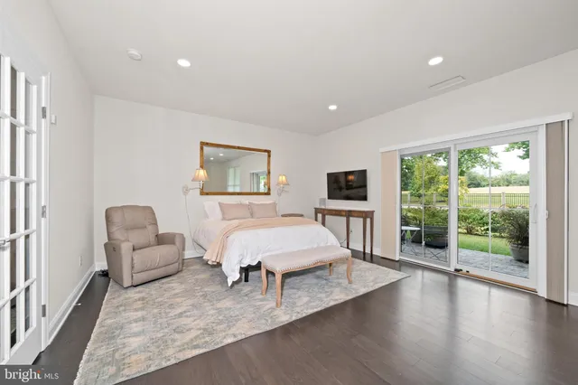 a spacious bedroom with a balcony a bed and large window