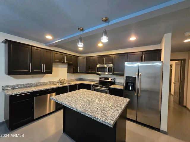 a kitchen with stainless steel appliances granite countertop a sink counter space cabinets and stainless steel appliances