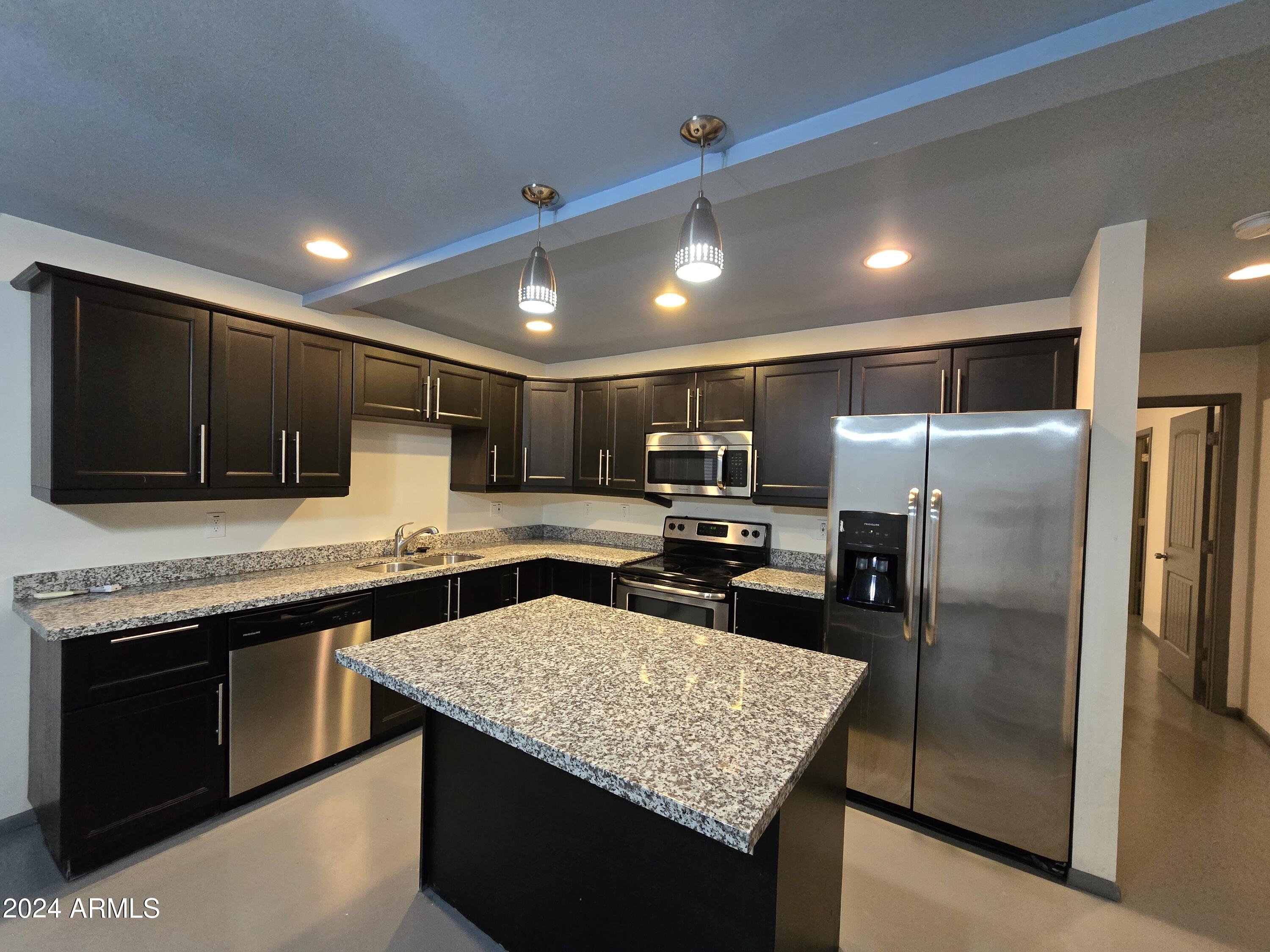 a kitchen with stainless steel appliances granite countertop a sink counter space cabinets and stainless steel appliances