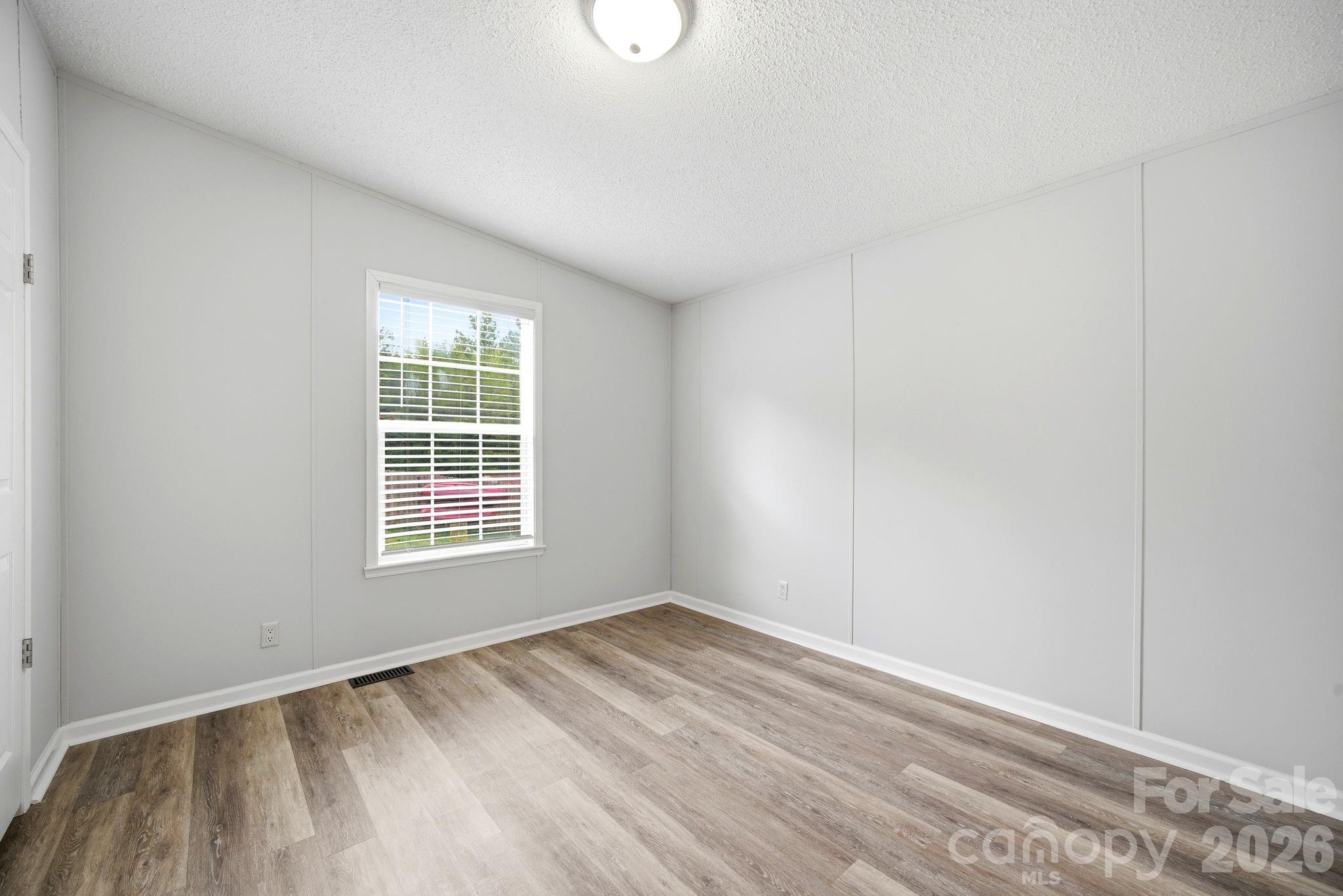 2368 Beth Haven Church Road Denver, NC 28037 - Photo 21 of 42 a view of an empty room with wooden floor and a window