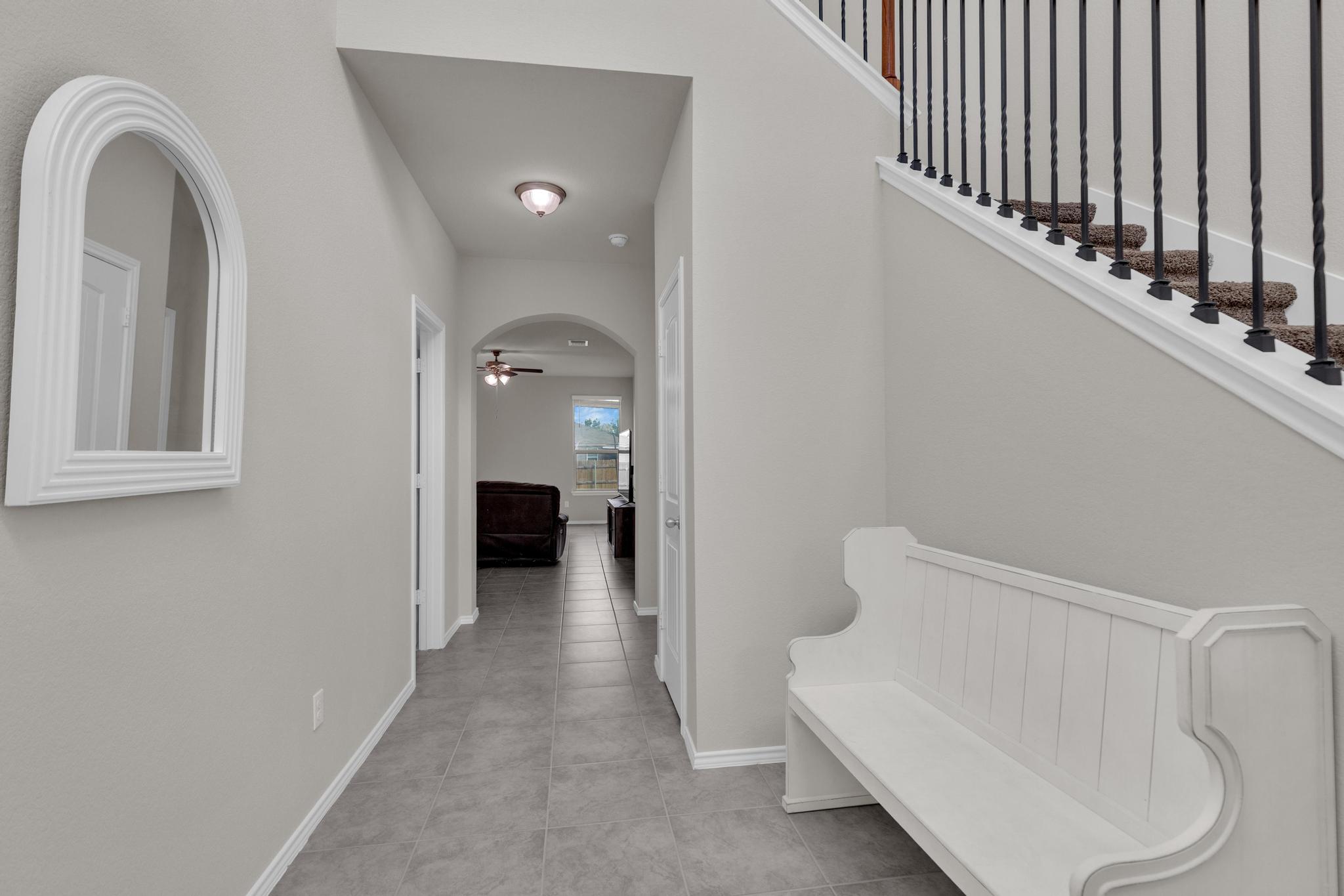 104 Uncle Billy Way Jarrell, TX 76537 - Photo 6 of 38 A well-lit entry hall with durable tile flooring and classic white trim, leading to a comfortable living area.