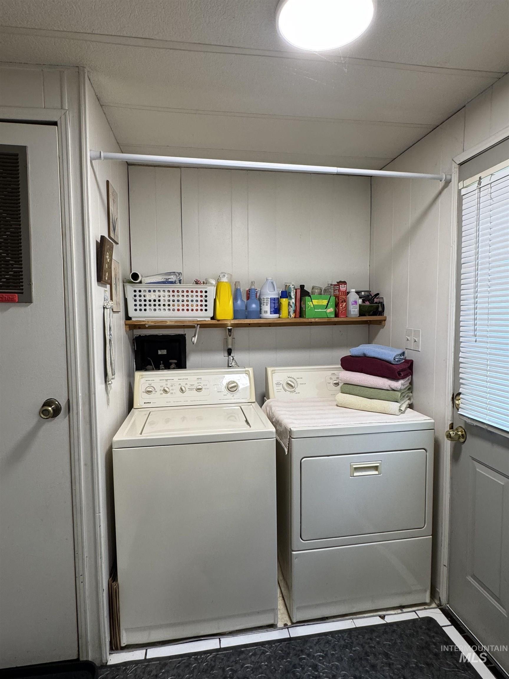 1200 Artesian Road, Unit 36 Eagle, ID 83616 - Photo 11 of 13 Dedicated laundry area with a washer and dryer, wood-finish shelving, and overhead lighting
