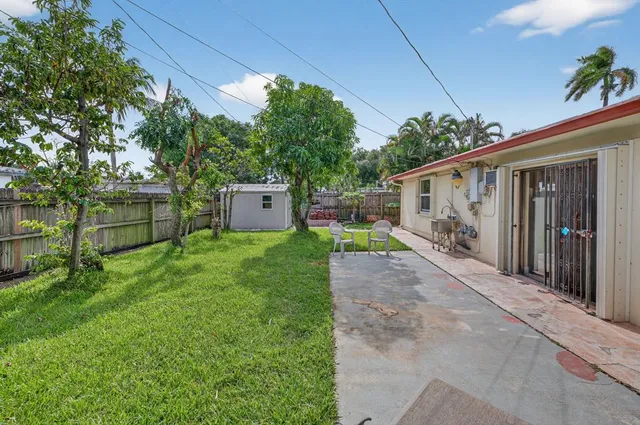 a view of a house with backyard and a tree