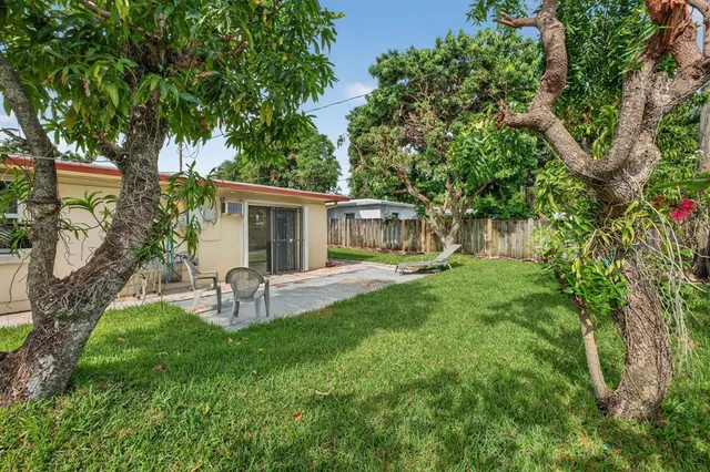 a view of a house with backyard and a sitting area