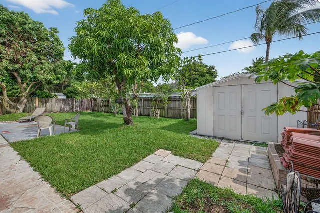 a view of backyard with table and chairs and potted plants