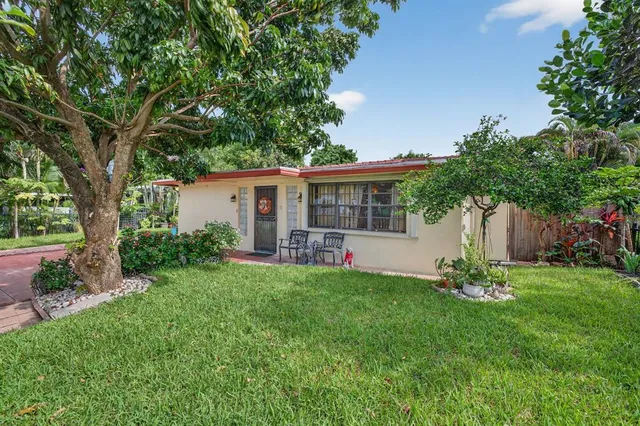 a view of a house with backyard and a tree