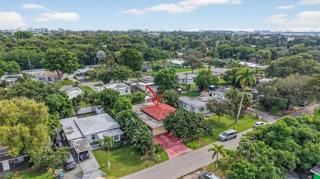 an aerial view of residential house with outdoor space and trees all around