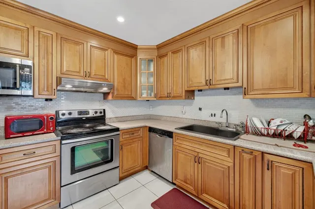a kitchen with stainless steel appliances granite countertop a sink stove and cabinets