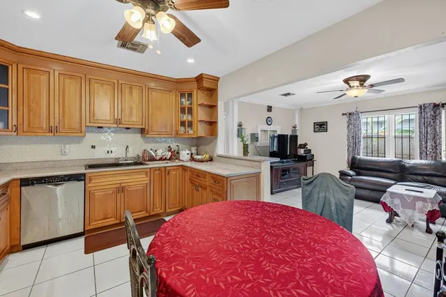 a kitchen with stainless steel appliances a stove a sink dishwasher and white cabinets with wooden floor