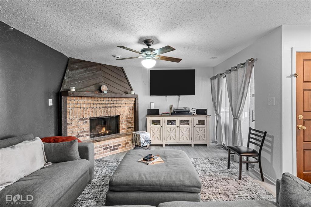 3100 Fairfield Avenue, Unit 10D Shreveport, LA 71104 - Photo 12 of 28 a living room with furniture a fireplace and a flat screen tv